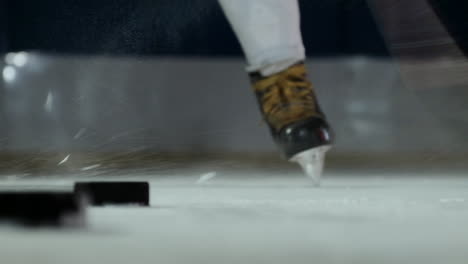 Close-up-of-the-puck-on-the-ice-and-the-hockey-player-strikes-the-puck-in-slow-motion